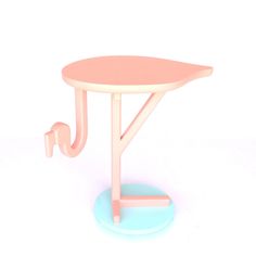 a small pink table with a blue base and two hooks on the top, against a white background