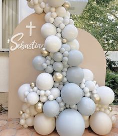 a white and silver christmas tree made out of balloons in front of a sign that says sebastian