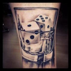 a black and white photo of dice in a glass with ice cubes on the leg