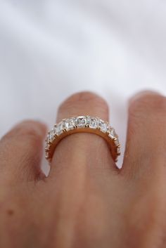 a woman's hand with a diamond ring on top of her finger, showing the band