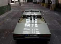 the back end of a car parked in an empty warehouse