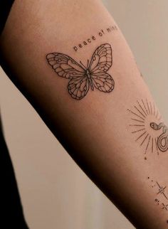 a woman's arm with a butterfly tattoo that reads peace on it and the sun is shining