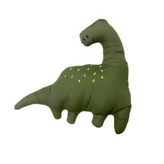 a green dinosaur pillow with yellow spots on it's face and neck, sitting in front of a white background