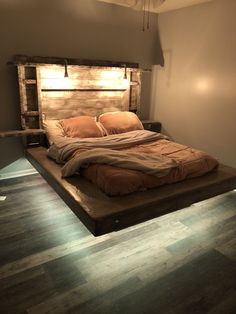 a bed made out of wood with lights on the headboard and foot board above it