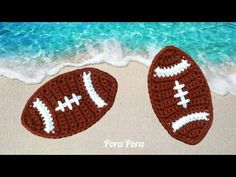 two crocheted footballs are on the beach