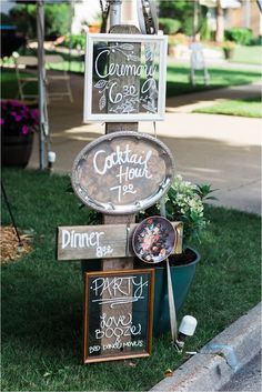 a sign that is sitting in the grass with some chalkboard on top of it