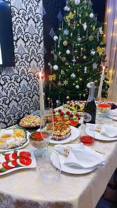 a christmas tree is decorated with lights and plates of food