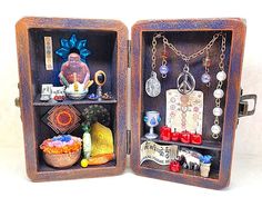 two open wooden boxes filled with jewelry and figurines on top of each other