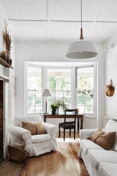 a living room filled with furniture and a fire place in front of a large window