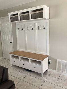 a room with a bench, cabinets and air conditioner on the wall in it