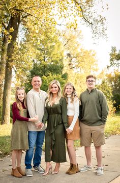 a family posing for a photo in front of some trees