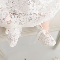 Close-up of a baby's feet wearing Rose Booties, tied with satin ribbons, with the edge of an heirloom lace dress visible. The background is subtly blurred. Elegant White Spring Booties, Elegant White Booties For Spring, Elegant Wedding Booties With Round Toe, Elegant Lace-up Booties For Spring, Elegant Fitted Booties With Closed Toe, Elegant Fitted Closed Toe Booties, Rose Outfit, Ceremony Outfit, Rose Gown