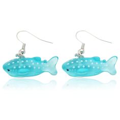 a pair of earrings with blue and white polka dots on the bottom, one has a fish