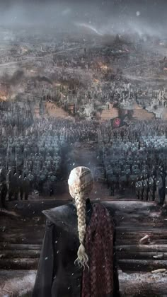 a woman with braids standing in front of a large group of people on a hill