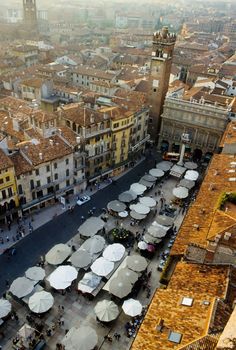 an aerial view of the city with tables and umbrellas