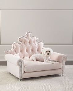 a small white dog sitting on top of a pink chair with diamond trimmings