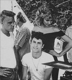 black and white photograph of two men and a woman in front of a record player