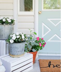 three potted flowers sitting on the front porch