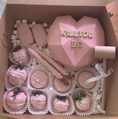 a box filled with chocolate covered strawberries next to a pink heart shaped box that says, will you be?