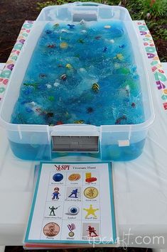 a plastic tub filled with blue liquid on top of a table next to a sign