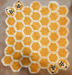 a crocheted honeycomb with two bees on the front and one bee on the back