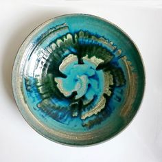 a blue and green bowl sitting on top of a white table