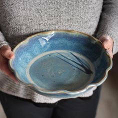 a person holding a blue bowl in their hands