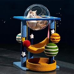 a cat sitting in a ball on top of a stand with balls and stars around it