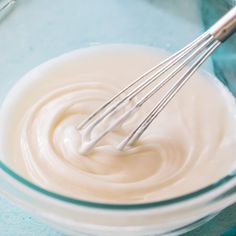 two whisks in a glass bowl filled with cream