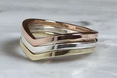 This gorgeous set of 14k yellow gold, 14k rose gold and sterling silver rings make a perfect everyday ring set. The mixed metals look beautiful together and they will sit comfortably on your finger, wear them together, or singly - so versatile. Dimensions: Each ring shank is square and is 1.5mm wide All of my jewelry comes in a gift box, with a ribbon, so it's ready for gift giving to friends or family - or a little treat just for you! If you have any questions, please email me! I'd love to spea V Rings, Triple Ring, Trio Ring, Arrow Ring, Rose Gold And Silver, Everyday Ring, Gold Rings Jewelry, Chevron Ring, Everyday Rings