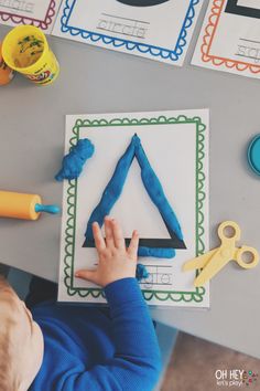 a young child is playing with some construction paper