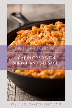 cajun orzo with shrimp and sausage in a cast iron skillet on a wooden table