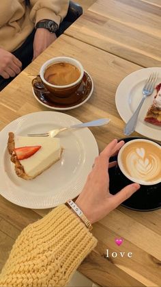 two people sitting at a table with plates of food and cups of coffee in front of them