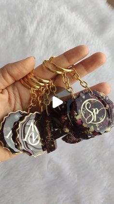 a person is holding two keychains in their hand with the letter s on them