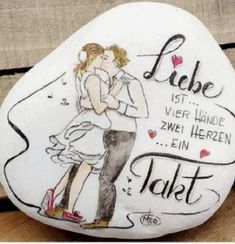 a painted rock with a couple kissing on it