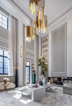 an elegant living room with white walls and gold chandeliers