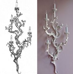 a white wall mounted candle holder next to a drawing of a chandelier