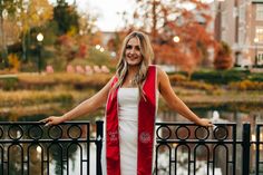 a woman is standing on a bridge with her arms spread out and smiling at the camera