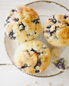 three blueberry muffins on a white plate