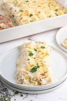 a white plate topped with food next to a casserole dish