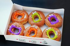 six doughnuts with googly eyes in a box