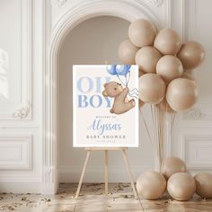 a baby shower sign with balloons in the air and a teddy bear holding a blue balloon