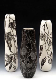 three black and white vases sitting next to each other