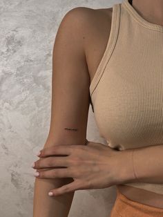 a woman's arm with a small tattoo on the left side of her arm