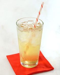 a glass with ice and a straw on a red napkin