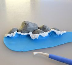 a toothbrush sitting on top of a blue plate with rocks and water in it