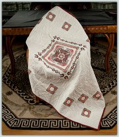 a table with a white and red quilt on it