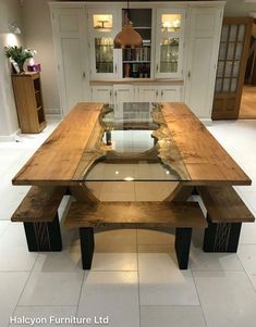 a wooden table sitting in the middle of a room with two benches on each side