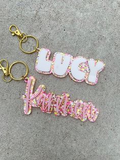 two key chains that say happy birthday and have sprinkles on them