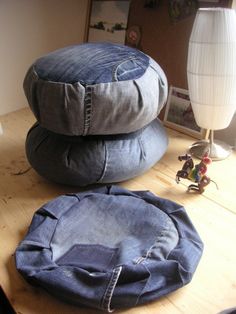 three denim pillows sitting on top of a wooden table